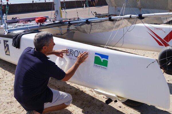 A crew adds our sponsors' stickers to his hull.